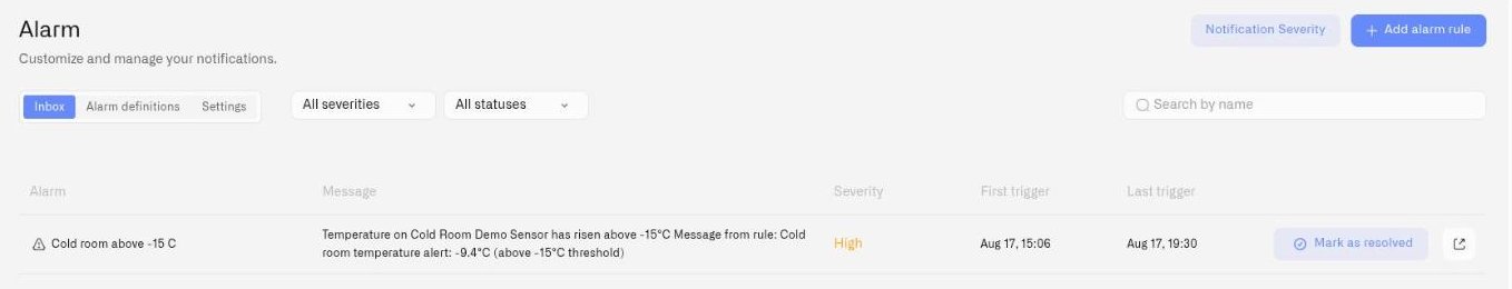 The Alarm page on the Inbox tab, with the Alarm definitions and Settings tabs, severity and status filters, and a triggered alarm